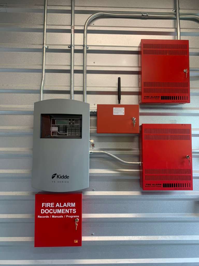 Red fire alarm panels on metal wall